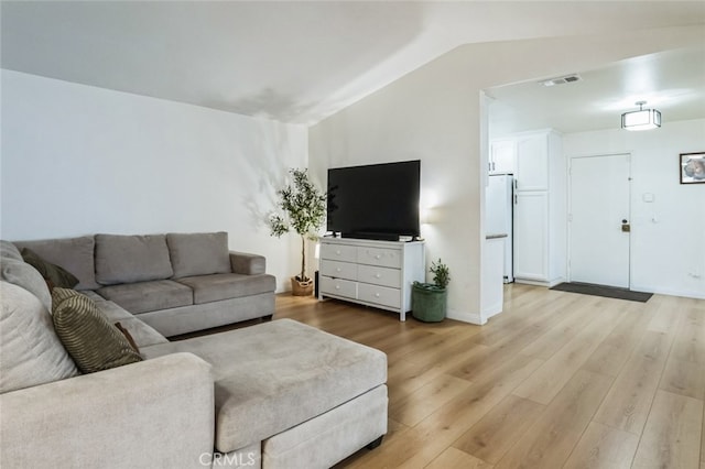 living area featuring visible vents, lofted ceiling, and light wood-type flooring