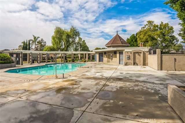 pool featuring fence and a patio area