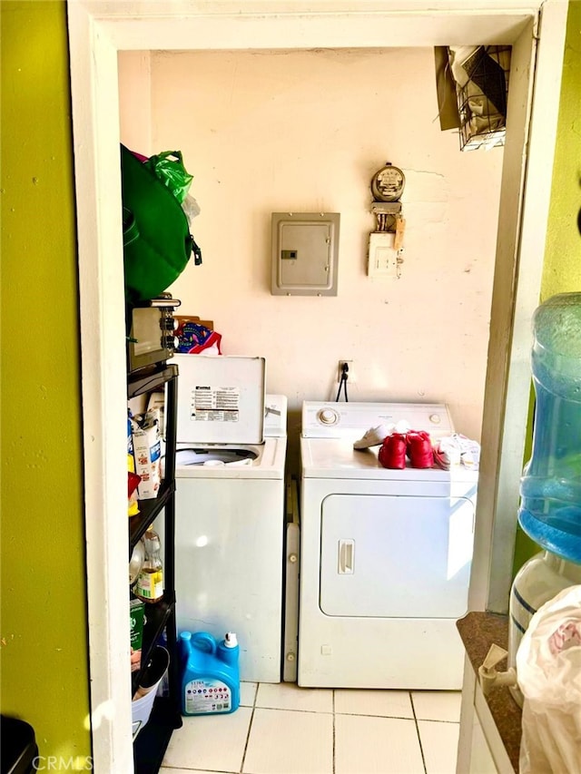 laundry area with light tile patterned flooring, electric panel, and washing machine and dryer