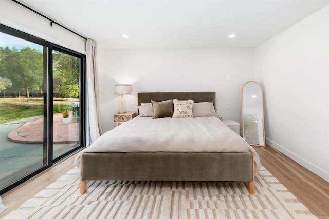 bedroom with access to outside and light wood-type flooring