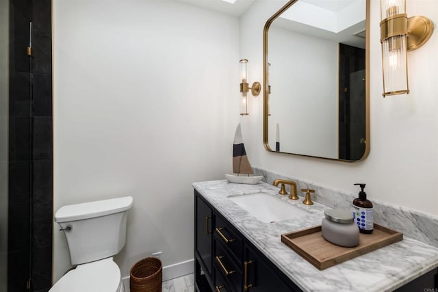 bathroom with vanity, a skylight, and toilet