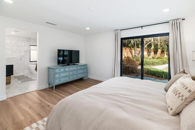 bedroom featuring a fireplace, ensuite bathroom, access to exterior, and light wood-type flooring