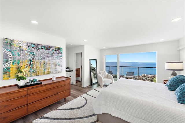 bedroom featuring a water view and dark hardwood / wood-style floors