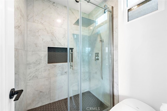 bathroom with a shower with shower door and toilet