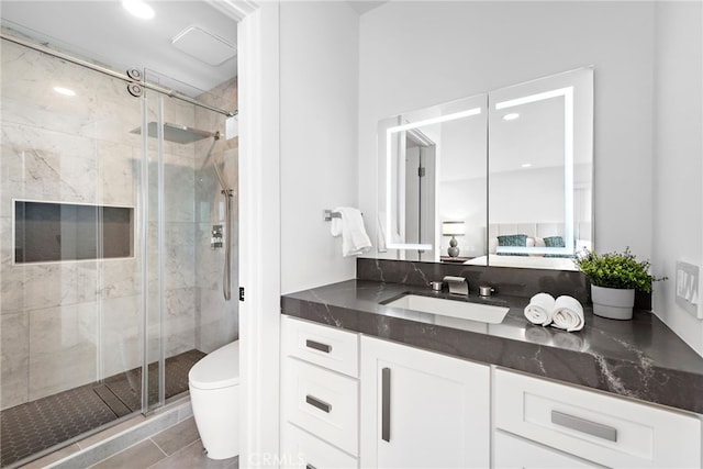 bathroom with an enclosed shower, vanity, tile patterned flooring, and toilet