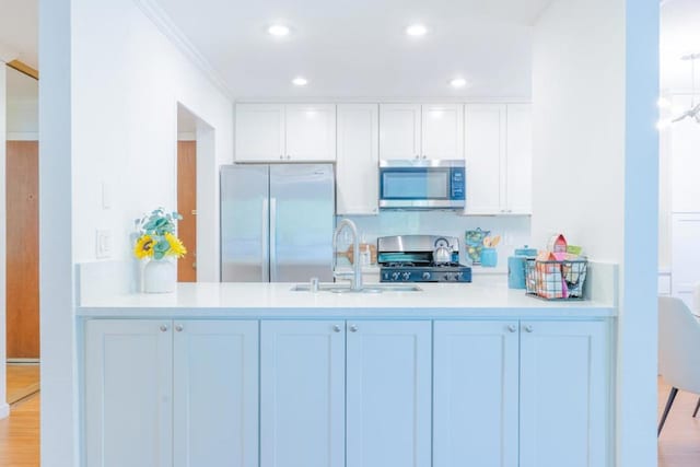 kitchen featuring sink, hardwood / wood-style floors, white cabinets, and appliances with stainless steel finishes