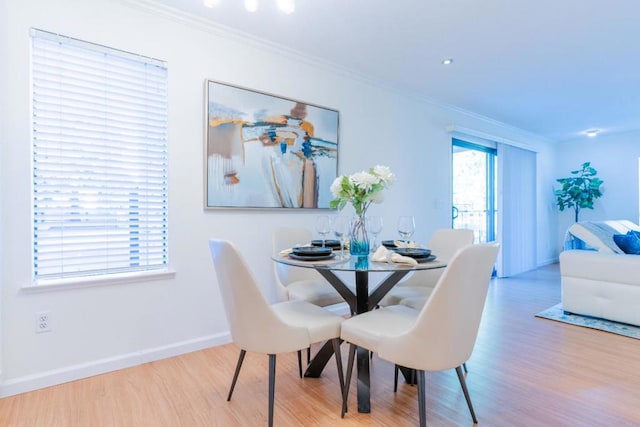 dining room featuring crown molding and light hardwood / wood-style flooring