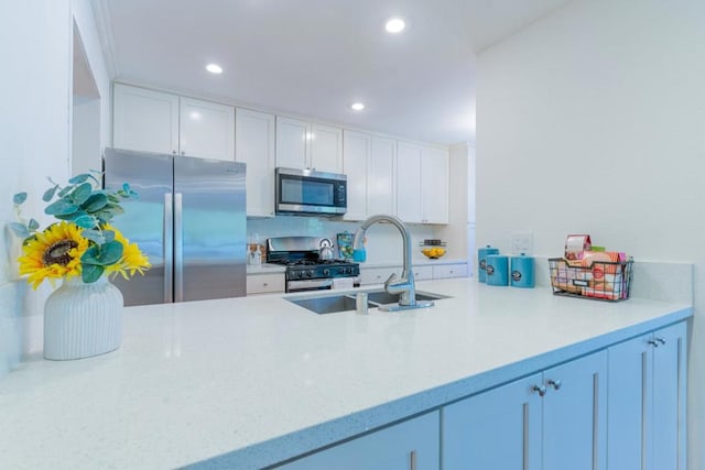 kitchen featuring light stone countertops, appliances with stainless steel finishes, sink, and white cabinets