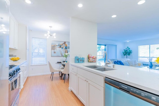 kitchen with sink, dishwasher, white cabinetry, range with gas stovetop, and light wood-type flooring