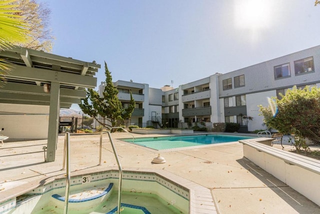 view of pool with a hot tub