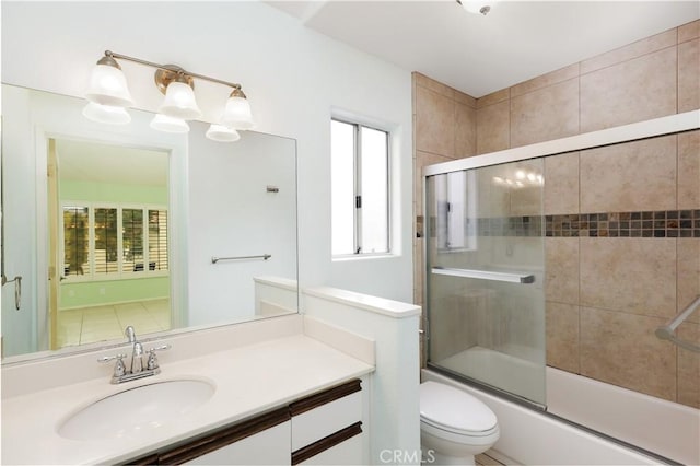 full bathroom featuring vanity, toilet, and combined bath / shower with glass door