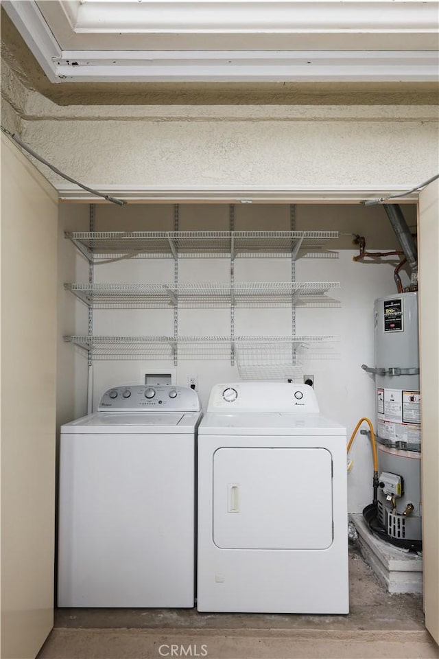 laundry room with washer and dryer and secured water heater