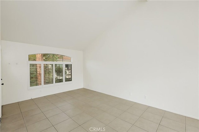 unfurnished room featuring light tile patterned flooring and lofted ceiling