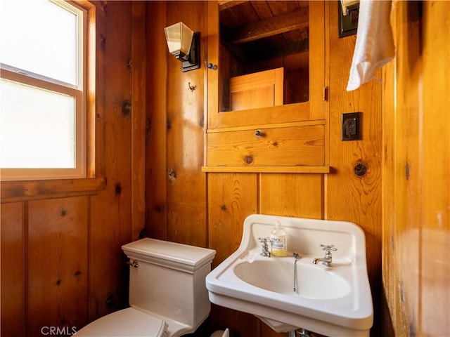 bathroom featuring wooden ceiling, toilet, sink, and wood walls