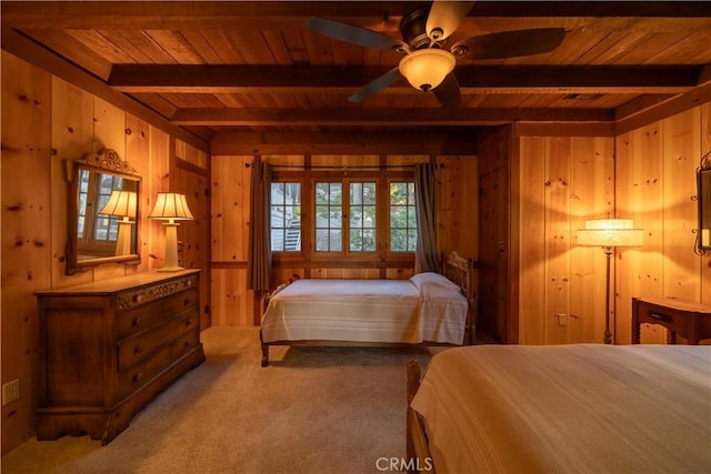 carpeted bedroom with wood ceiling, beam ceiling, ceiling fan, and wood walls