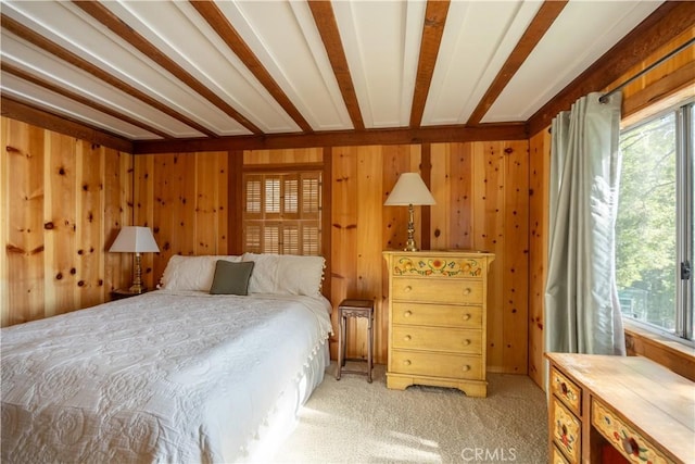 carpeted bedroom with beam ceiling