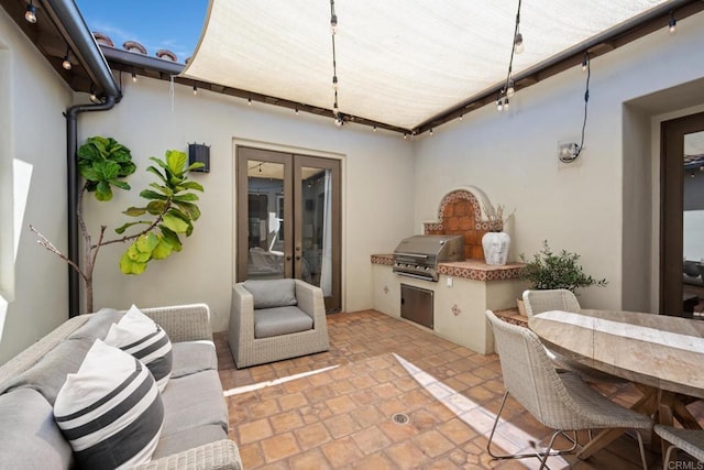 view of patio / terrace with a grill, french doors, and exterior kitchen