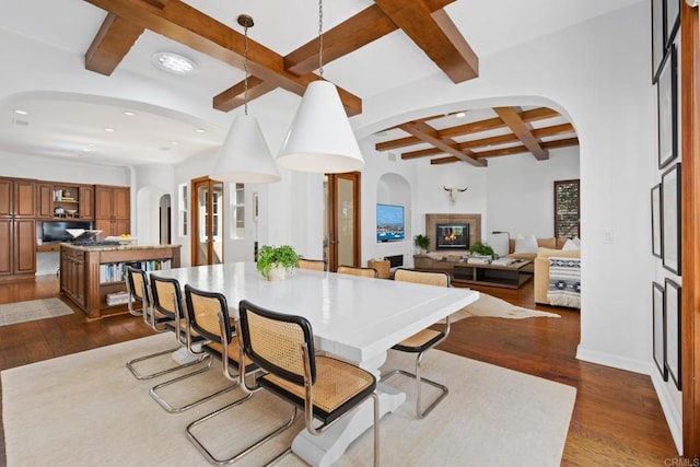 dining space featuring beamed ceiling, coffered ceiling, and dark hardwood / wood-style floors