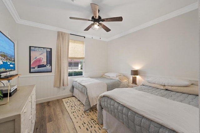 bedroom with light hardwood / wood-style flooring, ornamental molding, and ceiling fan