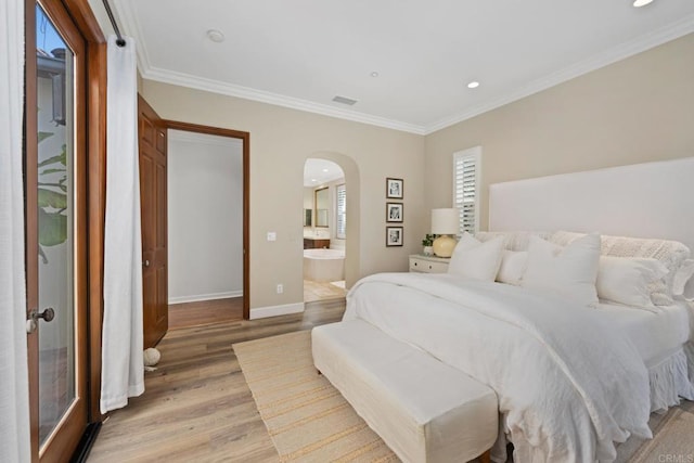 bedroom with light wood-type flooring, crown molding, and connected bathroom