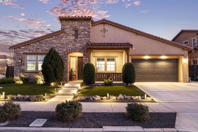 mediterranean / spanish house featuring a garage and a lawn