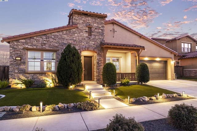 view of front of home with a garage and a lawn