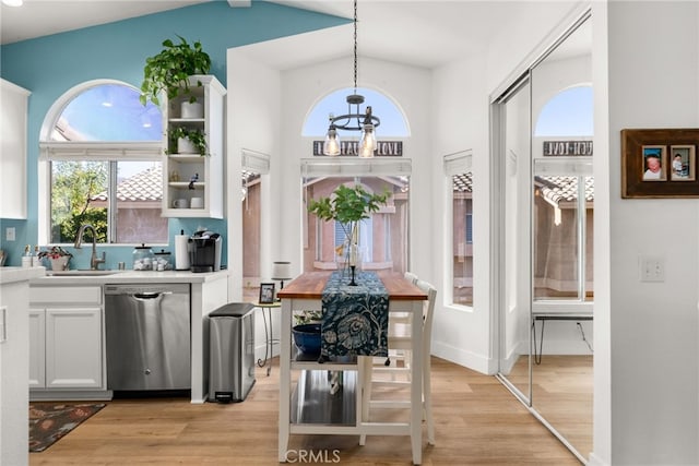 interior space featuring lofted ceiling, sink, and light wood-type flooring