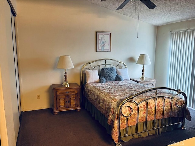 bedroom featuring dark carpet, a textured ceiling, ceiling fan, and a closet