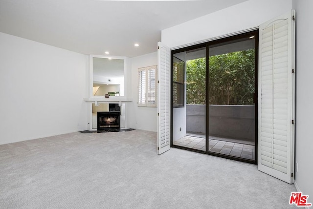 unfurnished living room featuring light colored carpet