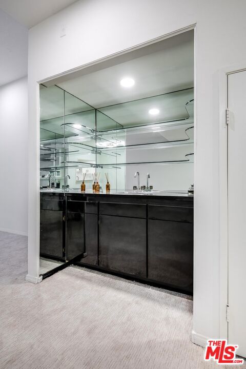 bar featuring sink and light carpet