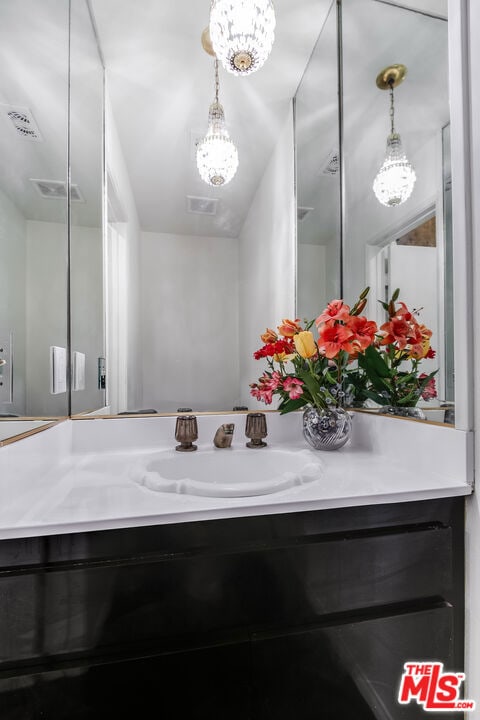 bathroom featuring vanity and a notable chandelier