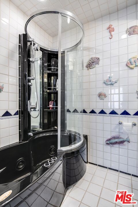 bathroom with tile patterned flooring and tile walls