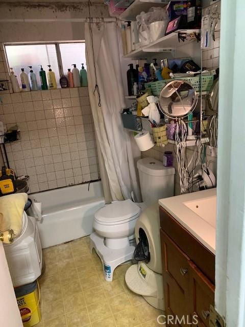 bathroom with tile patterned flooring, toilet, vanity, and shower / bath combination with curtain