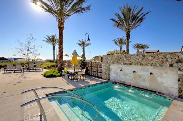 view of pool featuring a jacuzzi, a patio, and pool water feature