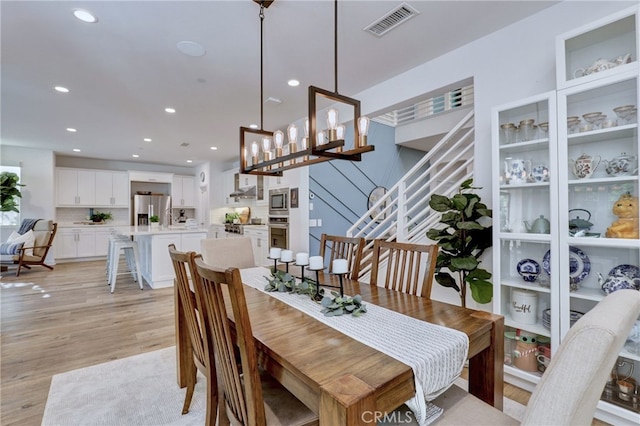 dining space with a chandelier and light wood-type flooring