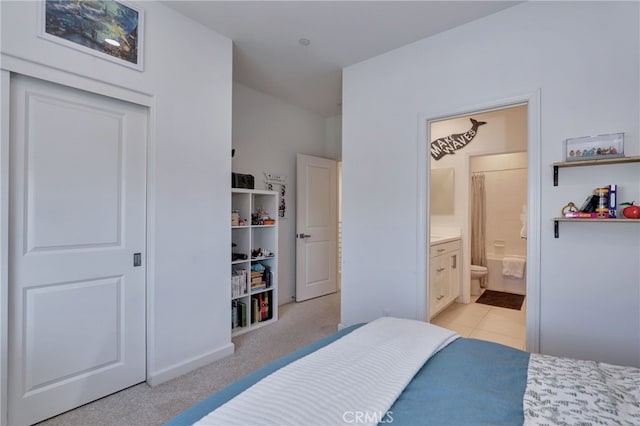 bedroom with light tile patterned floors and ensuite bath