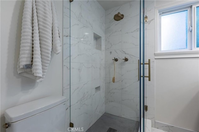 bathroom featuring toilet and a shower with shower door