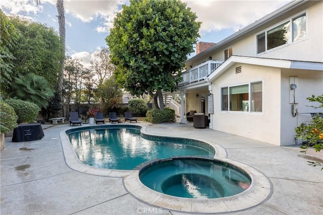 view of swimming pool featuring an in ground hot tub and a patio area