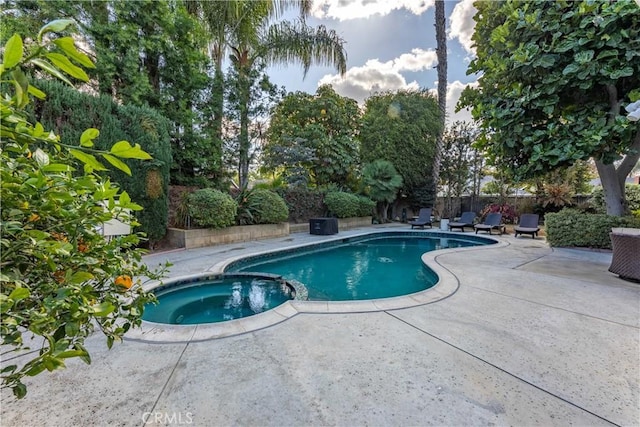 view of swimming pool featuring an in ground hot tub and a patio