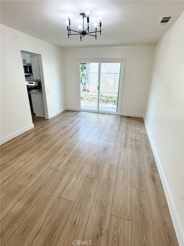 unfurnished dining area with a chandelier and light hardwood / wood-style flooring