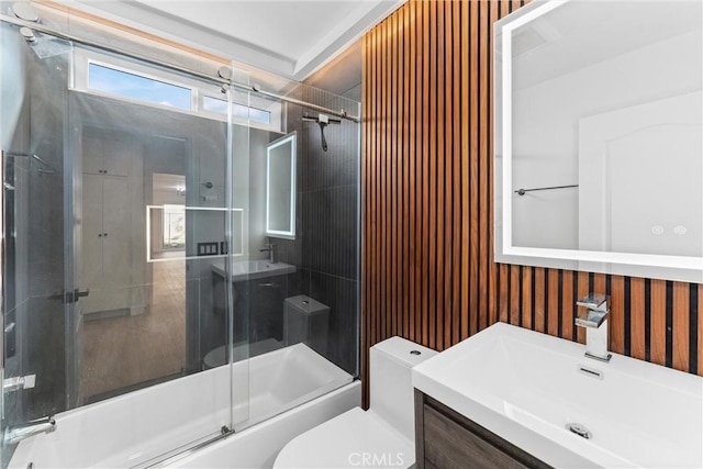 full bathroom featuring vanity, shower / bath combination with glass door, and toilet