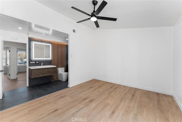 interior space with hardwood / wood-style flooring, ceiling fan, and sink