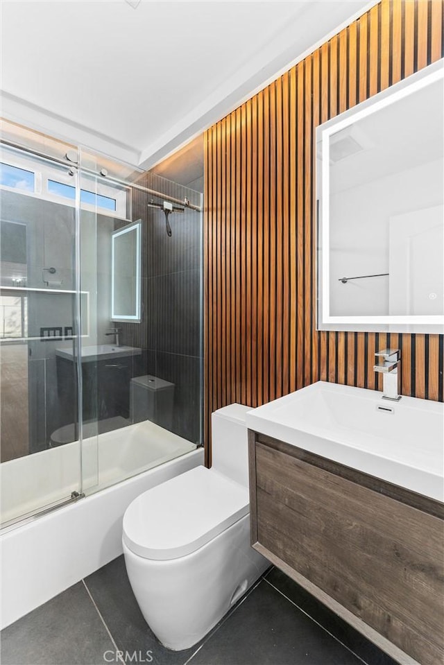 full bathroom with vanity, tile patterned flooring, shower / bath combination with glass door, and toilet