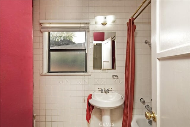 bathroom featuring tile walls, shower / tub combo with curtain, and backsplash