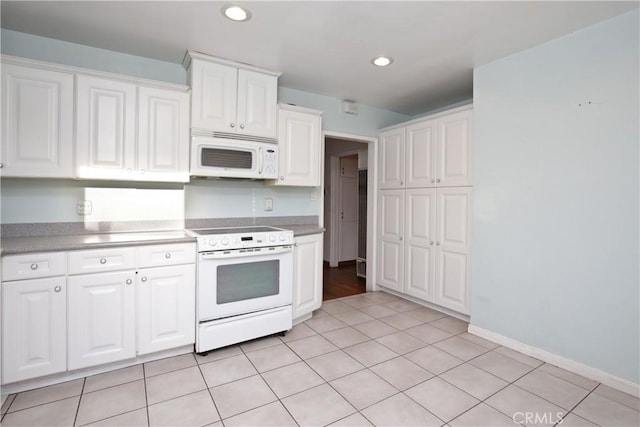 kitchen featuring light tile patterned flooring, white appliances, and white cabinets