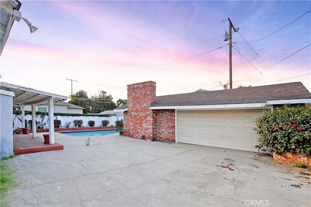 exterior space with a fenced in pool and a garage