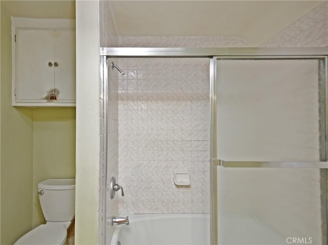 bathroom featuring shower / bath combination with glass door and toilet