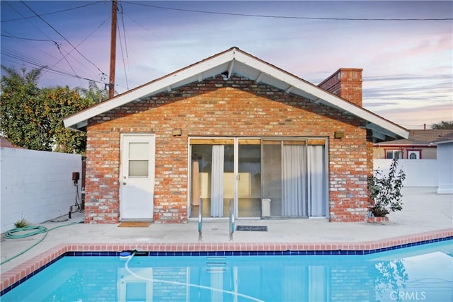 view of pool at dusk