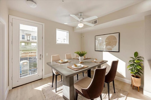 dining room featuring ceiling fan, light hardwood / wood-style flooring, and a healthy amount of sunlight