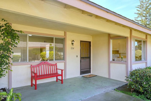 view of exterior entry with a patio